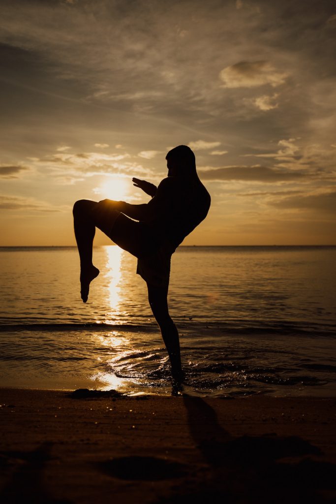 muay thai knee at the beach at sunset
